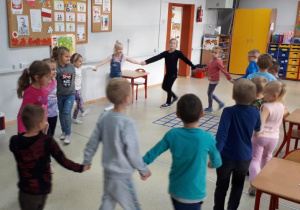 Dzieci tańczą w kole trzymając się za ręce